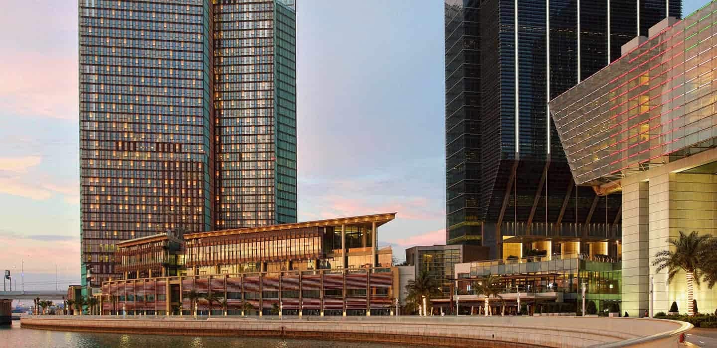 Grupa pracowników hotelowych odpoczywa na plaży po zmianie z drinkami w rękach