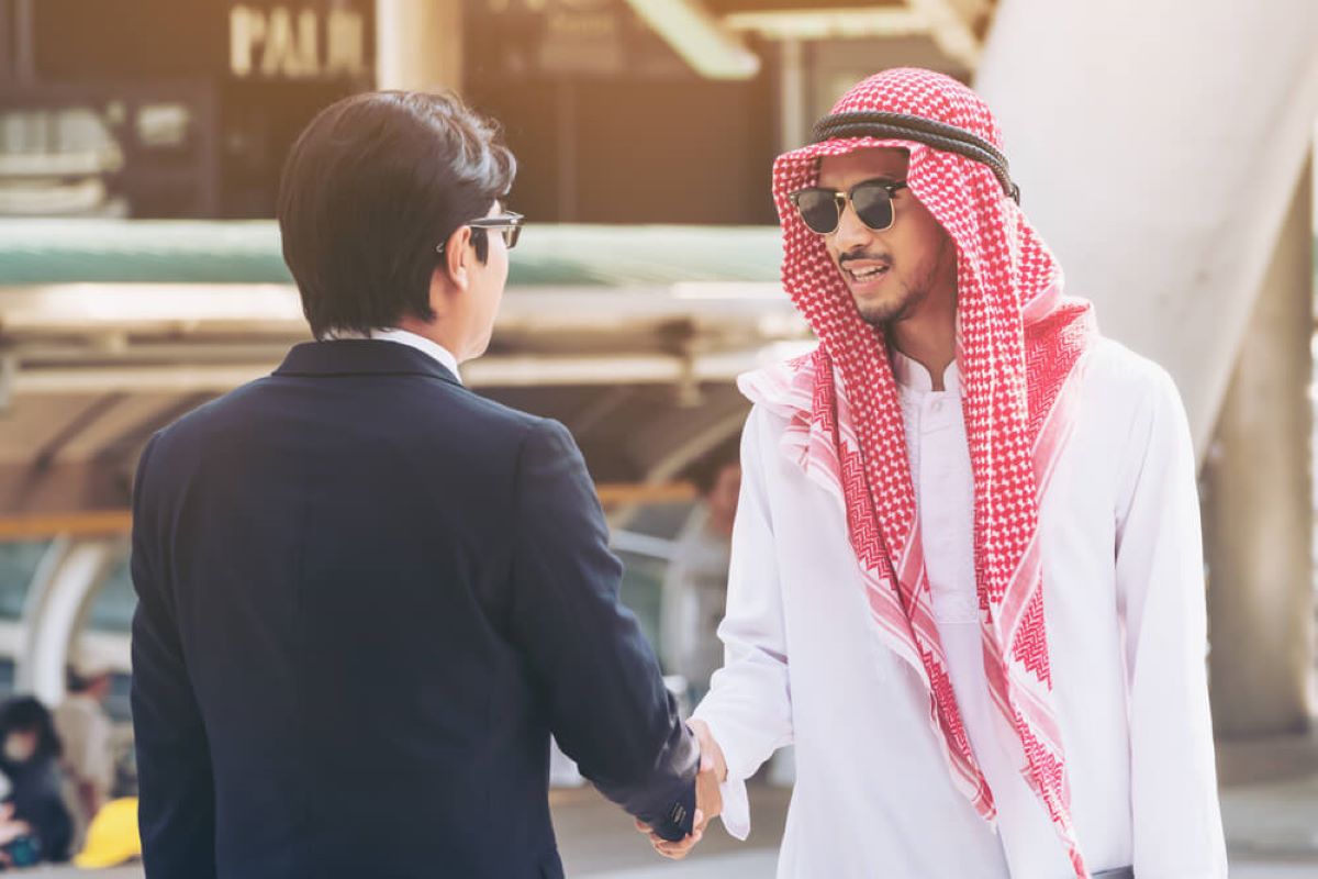 Hierarchia w arabskim środowisku biznesowym Szef w thobe przyjmuje delegację w luksusowym biurze z widokiem na Dubaj